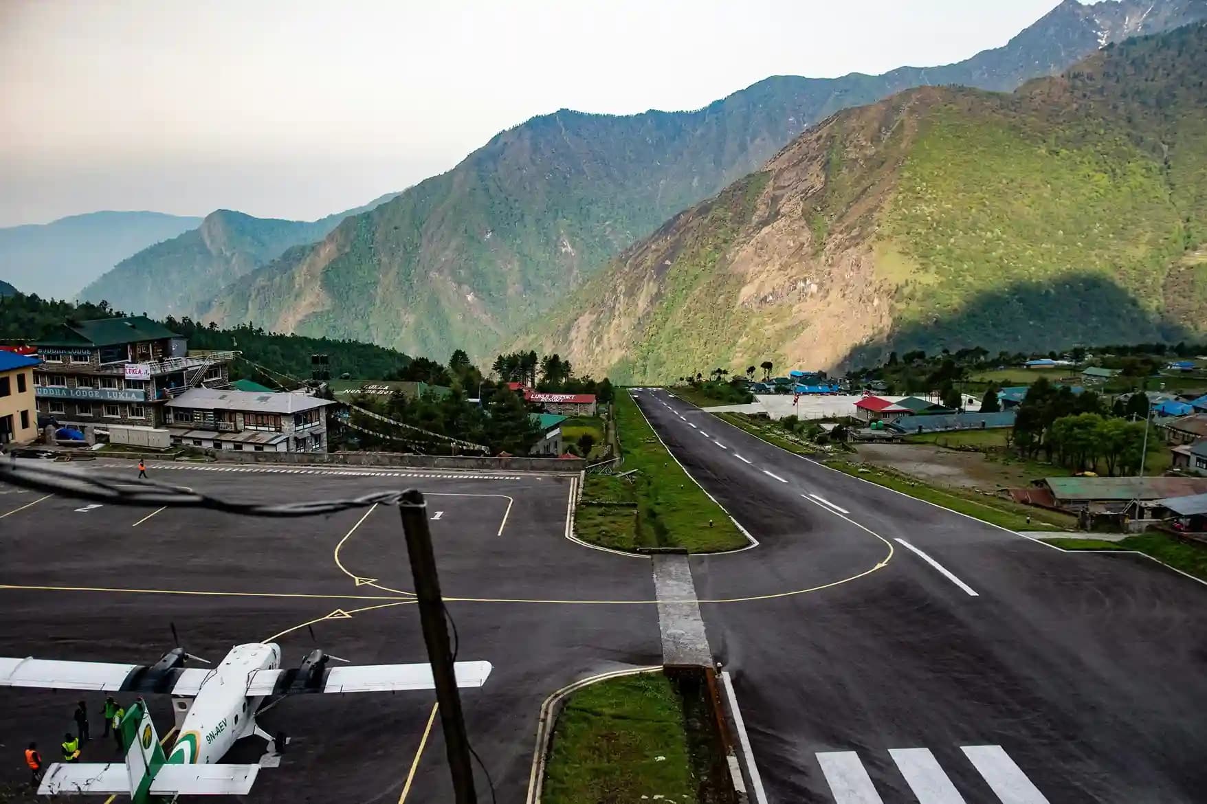 A small aircraft landing on the short, uphill runway of Tenzing-Hillary Airport in Lukla.