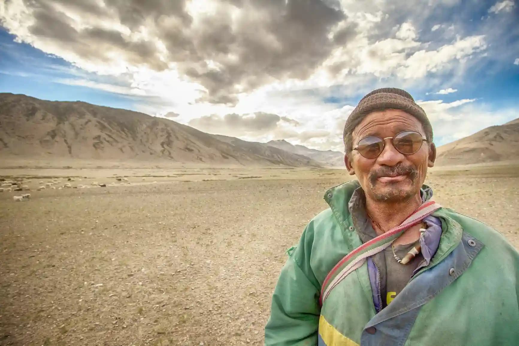 A smiling Sherpa guide or lodge owner welcoming guests inside a traditional mountain teahouse along the Everest Base Camp trail.